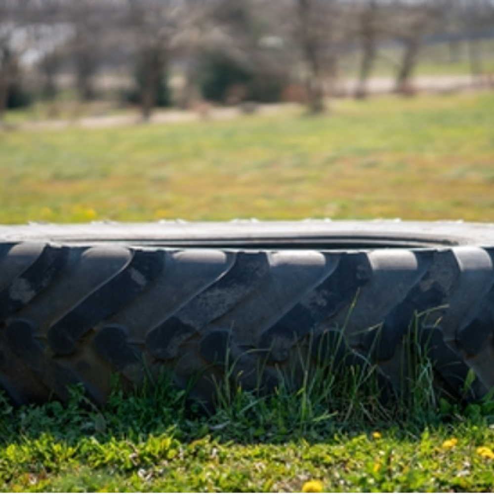 Heavy-duty agricultural tire resting on grassy terrain.